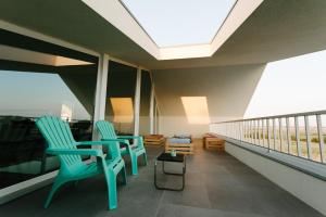 加法尼亞達伐基勒的住宿－Secret Guest House，阳台配有2把蓝色椅子和桌子