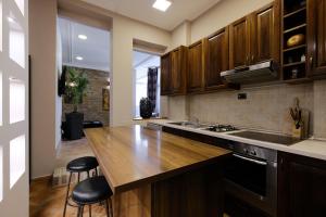 a kitchen with wooden cabinets and a wooden counter top at Ben Akiba Luxury Suites in Belgrade