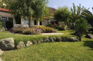 una casa con giardino fiorito e alberi di Casa Ischitana a Ischia