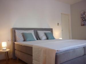 a bedroom with a large bed with blue pillows at Apartment Vesna in Supetar