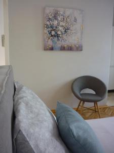 1 dormitorio con sofá, silla y pintura en Apartment Vesna, en Supetar