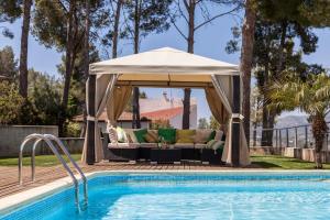 a gazebo next to a swimming pool at Villa Los Pinos 14 People AC Very confortable Outdoor area View Calm Area 10 minutes Drive From Sitges in Olivella