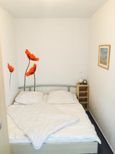 ドルム・ノイフェルトにあるHaus Amrum, Wohnung 17のベッドルーム1室(赤い花2本のベッド1台付)
