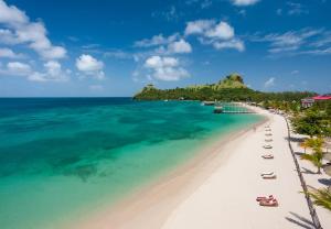 a view of a beach with chairs and the ocean at Sandals Grande St. Lucian Spa and Beach All Inclusive Resort - Couples Only in Gros Islet