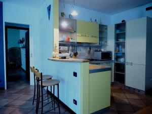 a kitchen with white cabinets and bar stools at Casa Vacanze Stefy in Pescantina