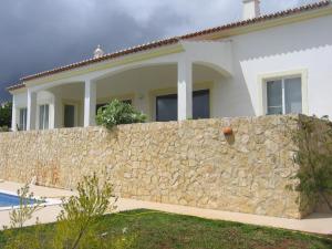 a stone wall in front of a house at Villa Casa do Monte in Silves