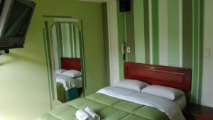 um quarto com 2 camas e um espelho em La Posada del Rey - Lima Airport Hostel em Lima