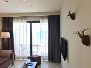 a living room with a couch and a window with a view at Palms and Spas Villas Retreat in Mesongi