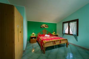1 dormitorio con paredes verdes, 1 cama y ventana en Villa Oasi del Relax, en Castellammare del Golfo
