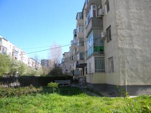 コンスタンツァにあるEva Apartmentの芝生の庭のあるアパートメントビル
