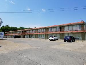 a large building with cars parked in a parking lot at Hermitage Inn in Hermitage