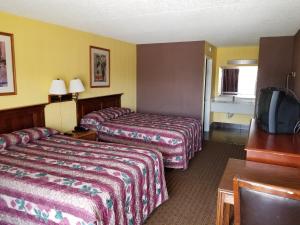 a hotel room with two beds and a flat screen tv at Hermitage Inn in Hermitage
