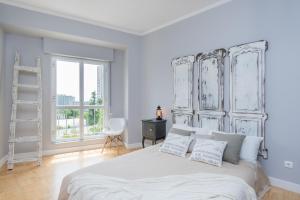 a white bedroom with a large bed and a window at Lisbon Airport Hostel in Lisbon