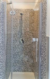 La salle de bains est pourvue d'une douche avec une porte en verre. dans l'établissement Capo House, à Palerme