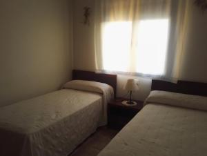 - 2 lits dans une petite chambre avec fenêtre dans l'établissement La Casa de Gonzala, à Belmonte