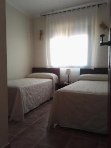 um quarto com 2 camas e uma janela com cortinas em La Casa de Gonzala em Belmonte