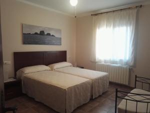 um quarto com 2 camas e uma janela em La Casa de Gonzala em Belmonte