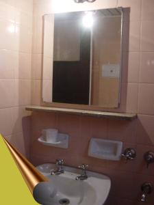 a bathroom with a sink and a mirror at Emperatriz HOTEL familiar in Santa Fe