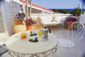 a white table with two glasses of orange juice at Vento d'aMare in Leporano