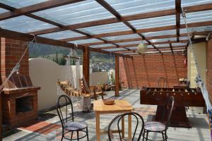 a patio with a table and chairs and a piano at Mashy´s Hostal in Otavalo