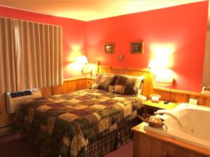 a hotel room with a bed and a lamp at Northwoods Inn & Suites Minocqua in Minocqua