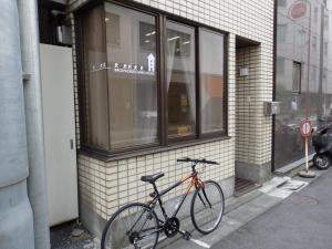 uma bicicleta estacionada ao lado de um edifício em Backpacker's Mini House em Tóquio