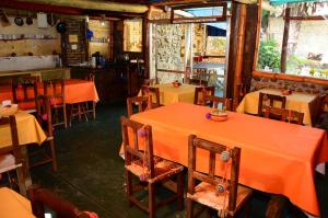 un restaurante vacío con mesas naranjas y sillas en Hostal Yatasto en Salta