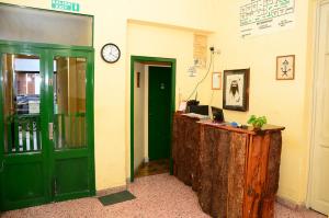 an office with green doors and a desk with a laptop at Hostal Yatasto in Salta