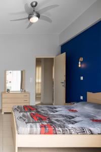 レティムノ・タウンにあるCentral Luxury Apartmentの青い壁のベッドルーム1室(大型ベッド1台付)