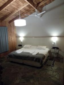 Un dormitorio con una gran cama blanca en una habitación. en Paralelo 42° Lodge, en El Maitén