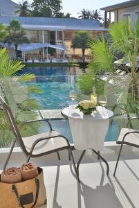 a table and chairs on a patio with a pool at Chi Samui Resort in Bophut