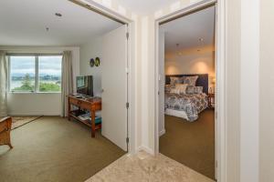 1 dormitorio con 1 cama y puerta corredera de cristal en Top Of The Town Bed & Breakfast, en Tauranga