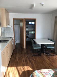 a kitchen with a table and a refrigerator at Sea Vu Caravan Park in Robe
