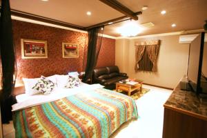 um quarto de hotel com uma cama e um sofá em Aura Kanku (Adult Only) em Sennan