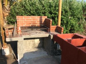 Una parrilla de ladrillos colocada encima de un patio. en Casa Maria, en El Cebollito