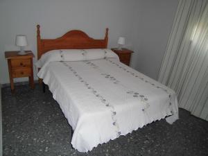 a bedroom with a white bed with two night stands at Vivienda Rural Alcazaba in Chipiona