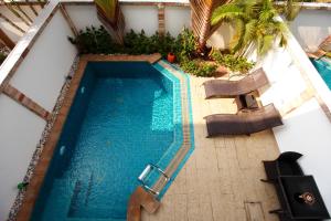 - une vue sur la piscine bordée de chaises et de palmiers dans l'établissement Hidden Palm Pool Villas, à Pattaya (nord)