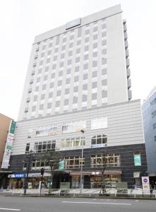 a large building with a clock on the front of it at R&B Hotel Hachioji in Hachioji