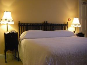 a bedroom with a large bed with two lamps at Stella Maris Shore House in Ballycastle