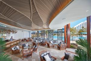 a hotel lobby with chairs and tables and a pool at Crown Towers Perth in Perth