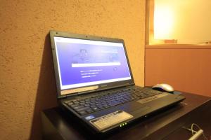 a laptop computer sitting on a desk with a mouse at R&B Hotel Sendai Hirosedori Ekimae in Sendai