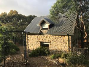 a stone house with a metal roof at The Stone Cottage in Hobart