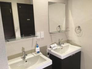 a bathroom with two sinks and a mirror at TIMES INN 2F in Tokyo