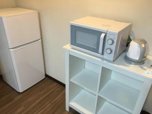 a microwave sitting on a table next to a refrigerator at TIMES INN 2F in Tokyo