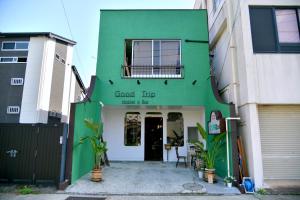 Good Trip Hostel & Bar في أوداوارا: مبنى أخضر مع مدخل من الأمام إلى متجر
