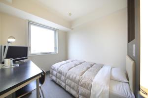 מיטה או מיטות בחדר ב-R&B Hotel Kamata Higashiguchi
