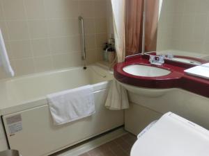 a bathroom with a sink and a toilet and a tub at Prince Hotel Shimonoseki in Shimonoseki