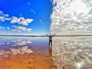 Un uomo in piedi su una spiaggia con le braccia tese di BIG4 Riverside Swan Hill a Swan Hill