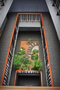 a spiral staircase with a garden on a building at Merdelong Hotel in Phatthalung