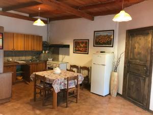 una cucina con tavolo e frigorifero bianco di Casa vacanze Porto Selvaggio a Santa Caterina di Nardò